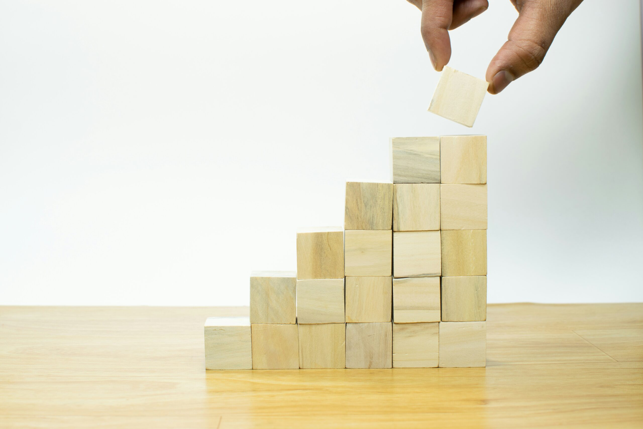 Hand stacking wooden blocks into a staircase